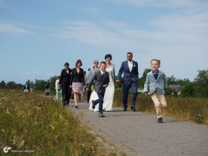 Hochzeitsgesellschaft auf Hiddensee spaziert über den Deich